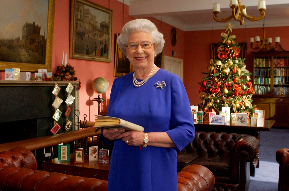 Queen Elizabeth smiles in front of a Christmas tree.