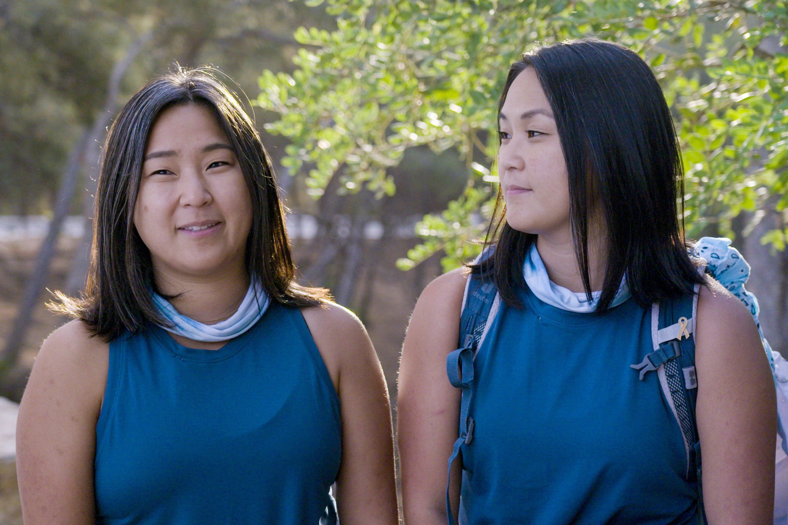 Emily Bushnell and Molly Sinert, who starred in 'The Amazing Race 34' on CBS, film a confessional. The twins wear matching teal tank tops and light blue bands around their necks.