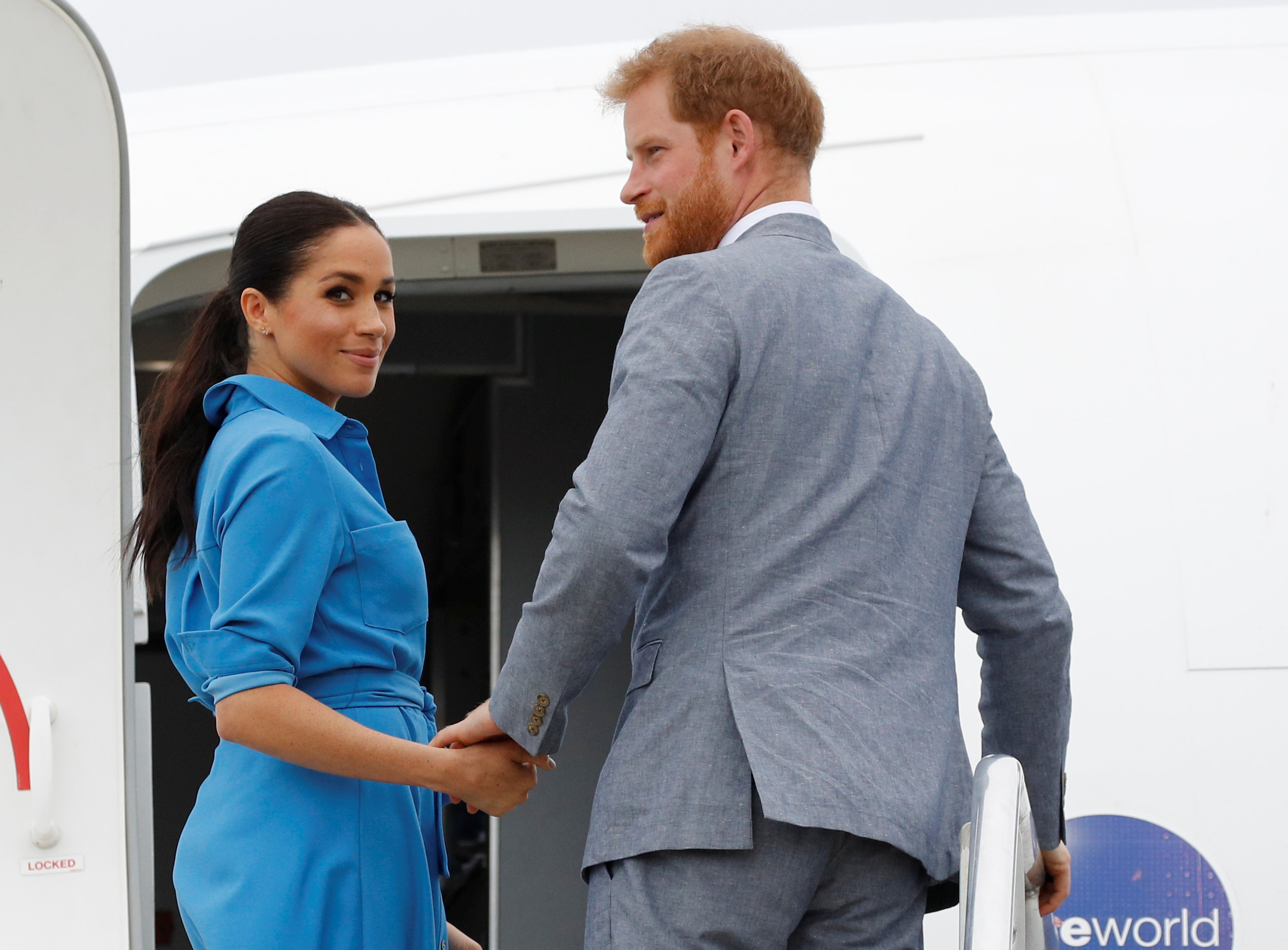 Meghan Markle and Prince Harry step inside an airplane in 2018.