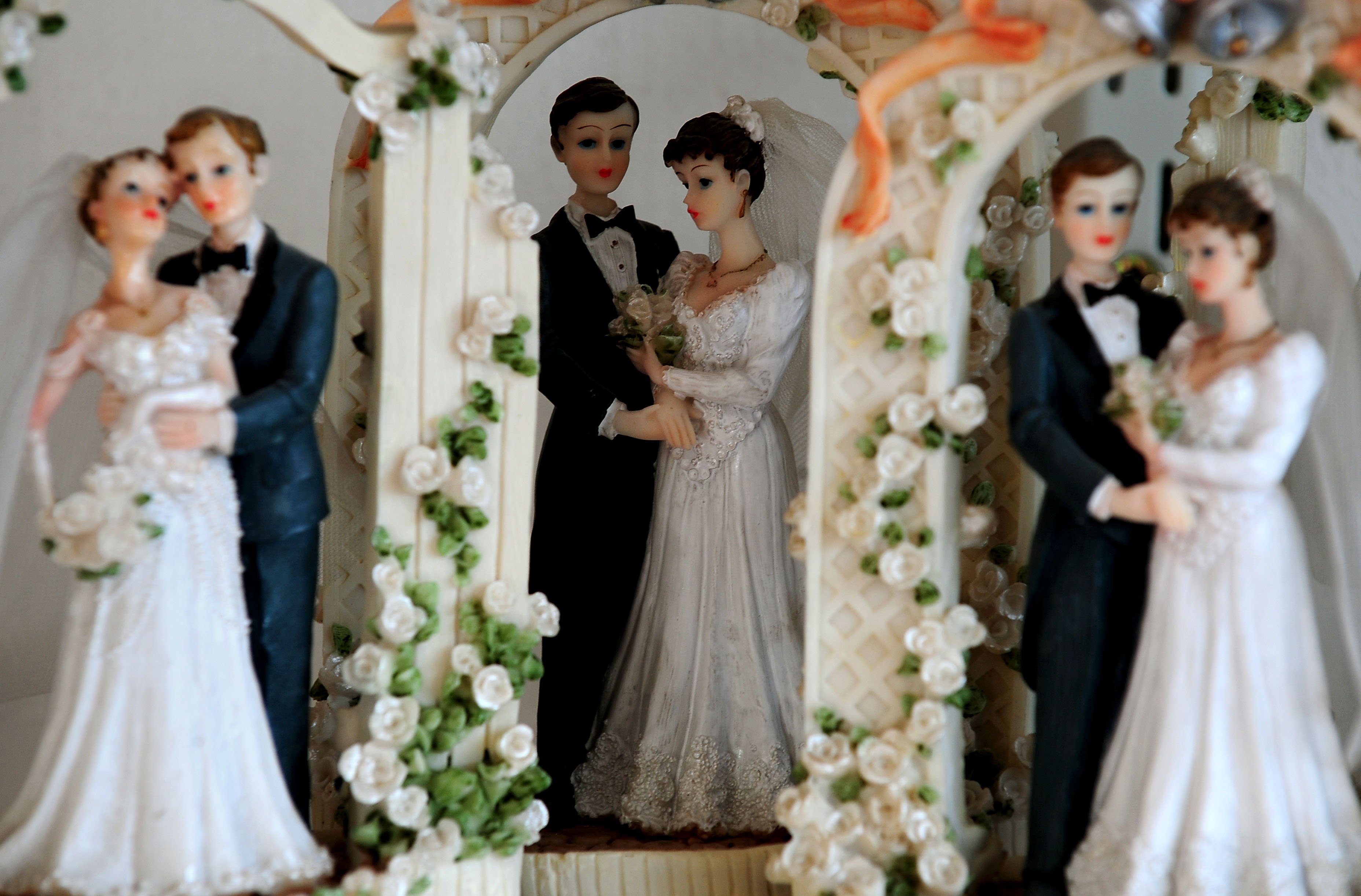 a trio of bride and groom cake decorations