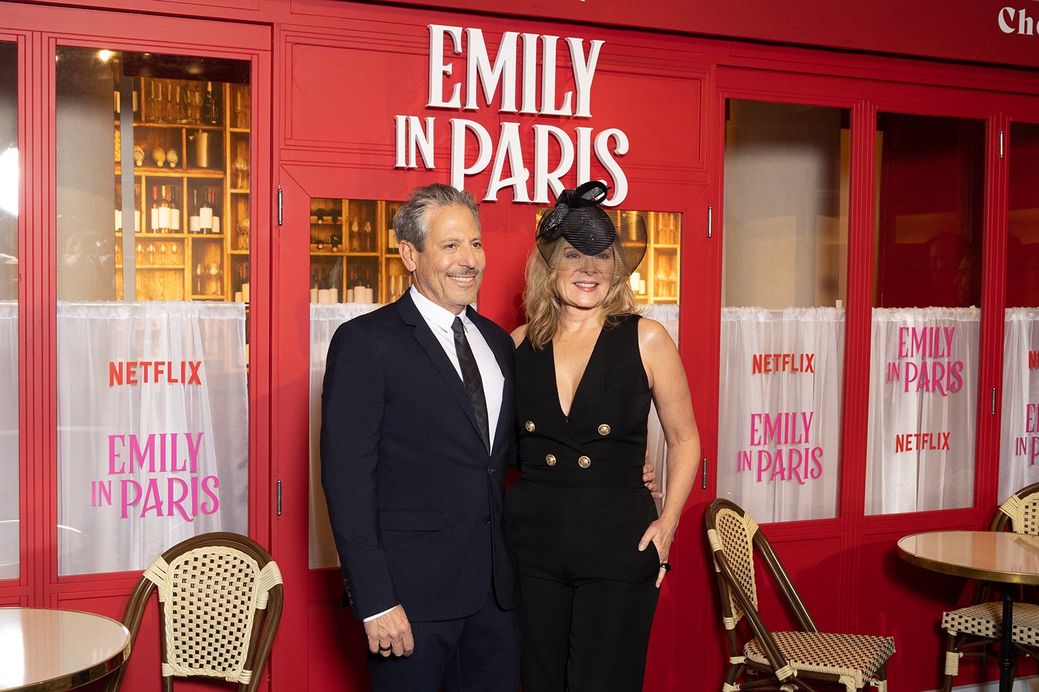 Darren Star and Kim Cattrall pose together in black clothing at the Emily in Paris Season 3 premiere red carpet event.