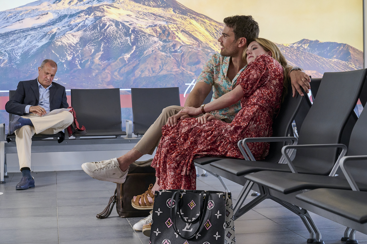 Cameron (Theo James) and Daphne (Meghann Fahy) cuddling in the airport in 'The White Lotus Sicily'