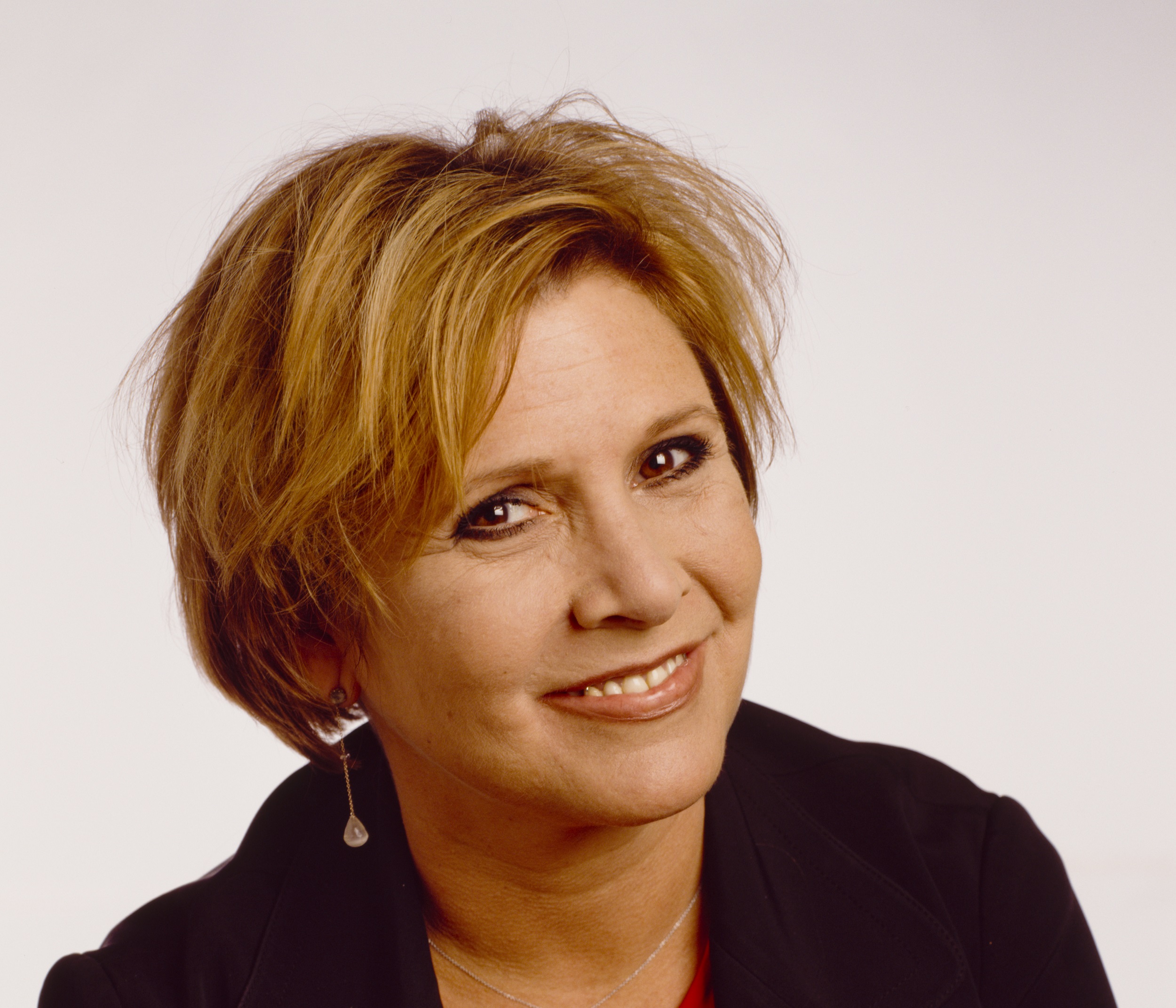 Carrie Fisher wearing a black sweater poses for a headshot