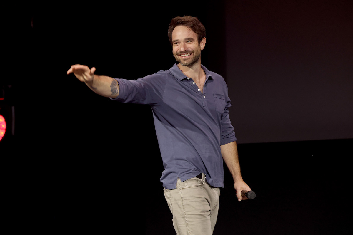 Charlie Cox waves to the crowd onstage during the D23 event.