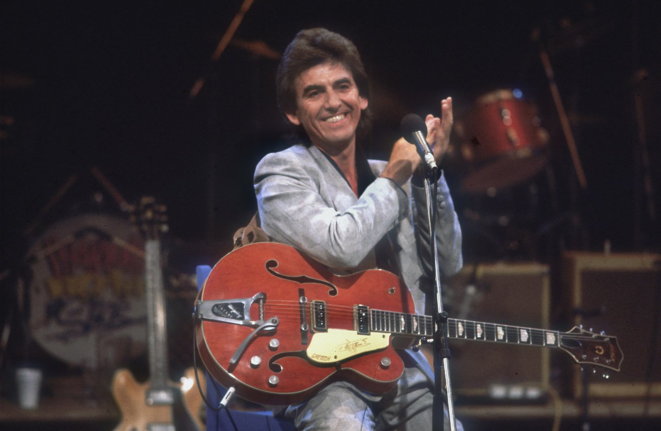 George Harrison wearing a silver suit while performing at Ferry Aid in 1987.