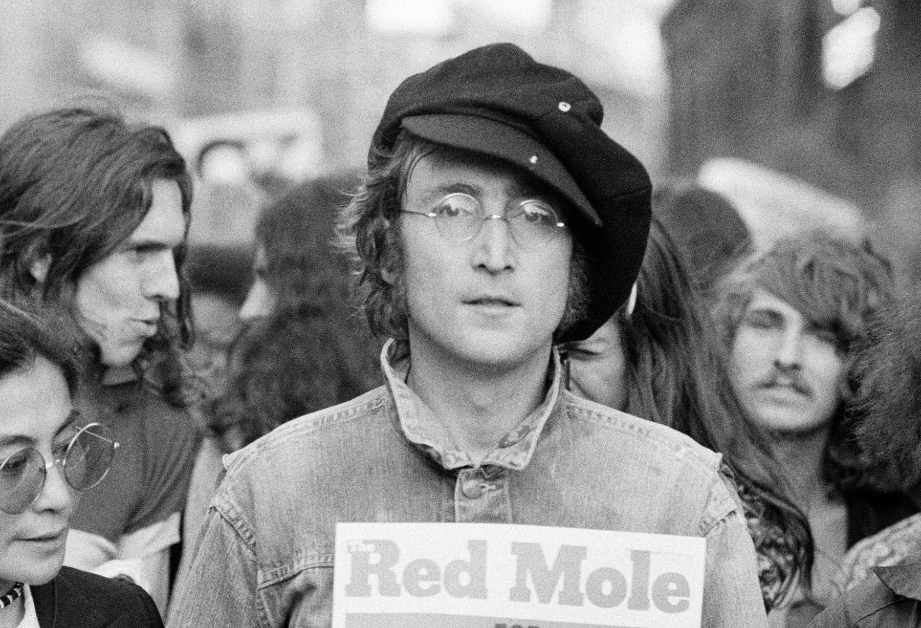 Portrait of British musician John Lennon and his wife, artist and musician Yoko Ono (extreme left) as they attend an unspecified rally