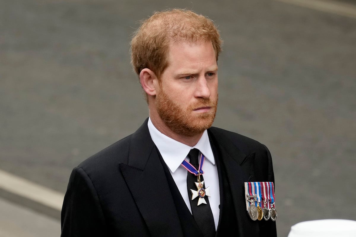 Prince Harry looks somber while walking in a funeral procession for his grandmother, Queen Elizabeth.