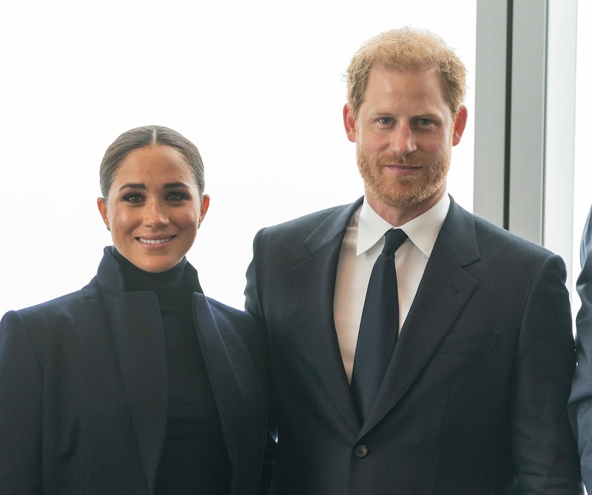 Meghan Markle and Prince Harry smile and pose together at an event.