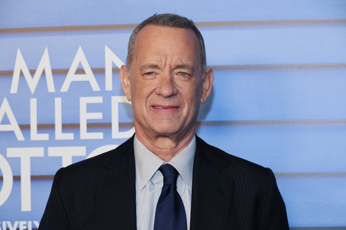 Tom Hanks poses for photos in front of a backdrop with the logo for "A Man Called Otto" I