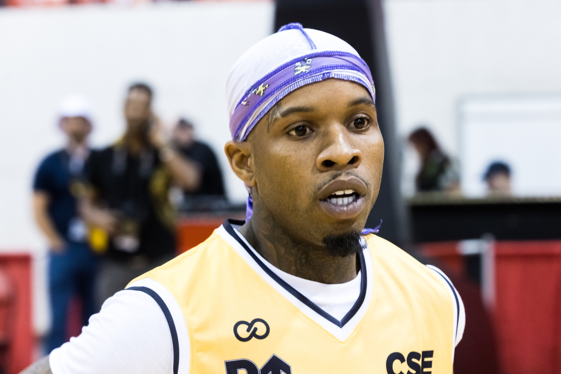 Tory Lanez, who is represented by Snoop Dogg and Casey Anthony's former lawyers, wearing a yellow jersey and purple durag