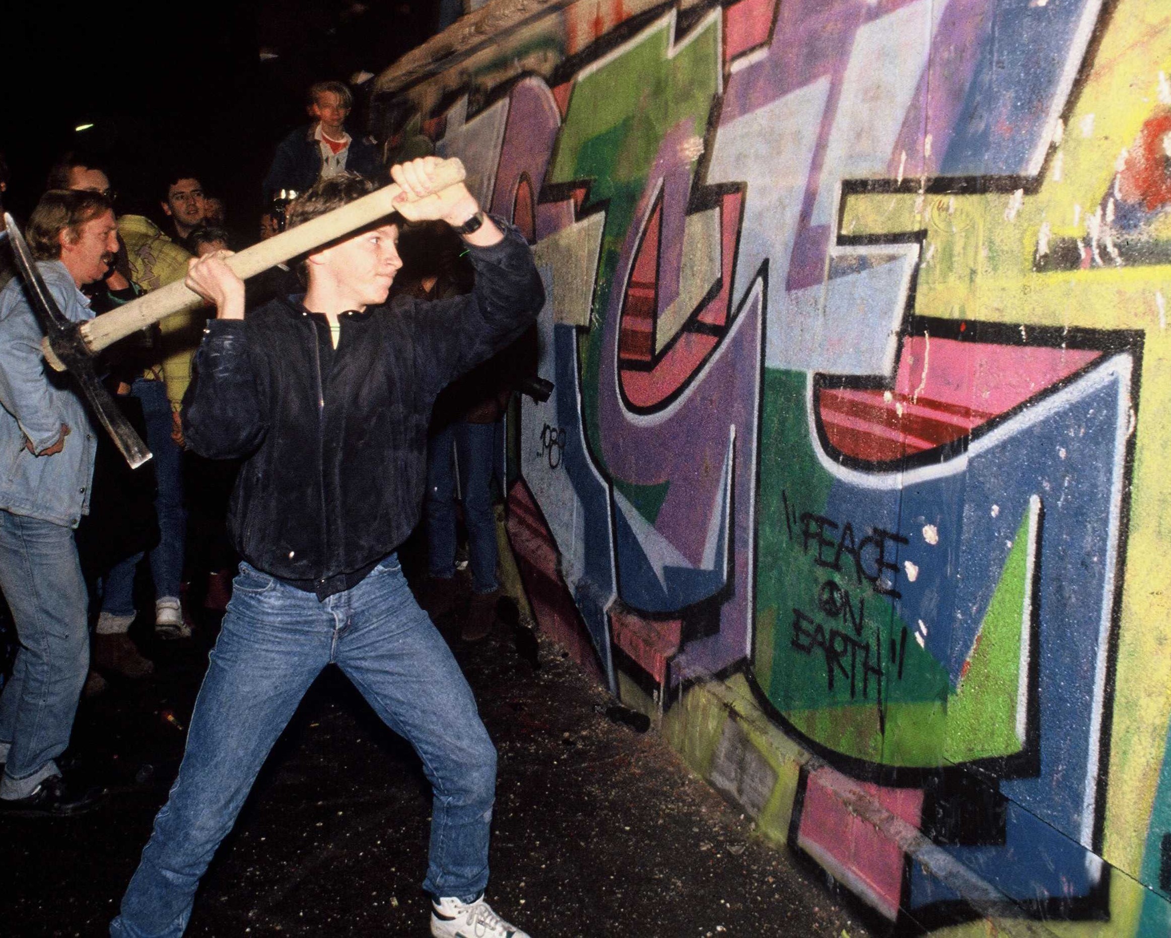 Someone hitting the Berlin Wall with an axe