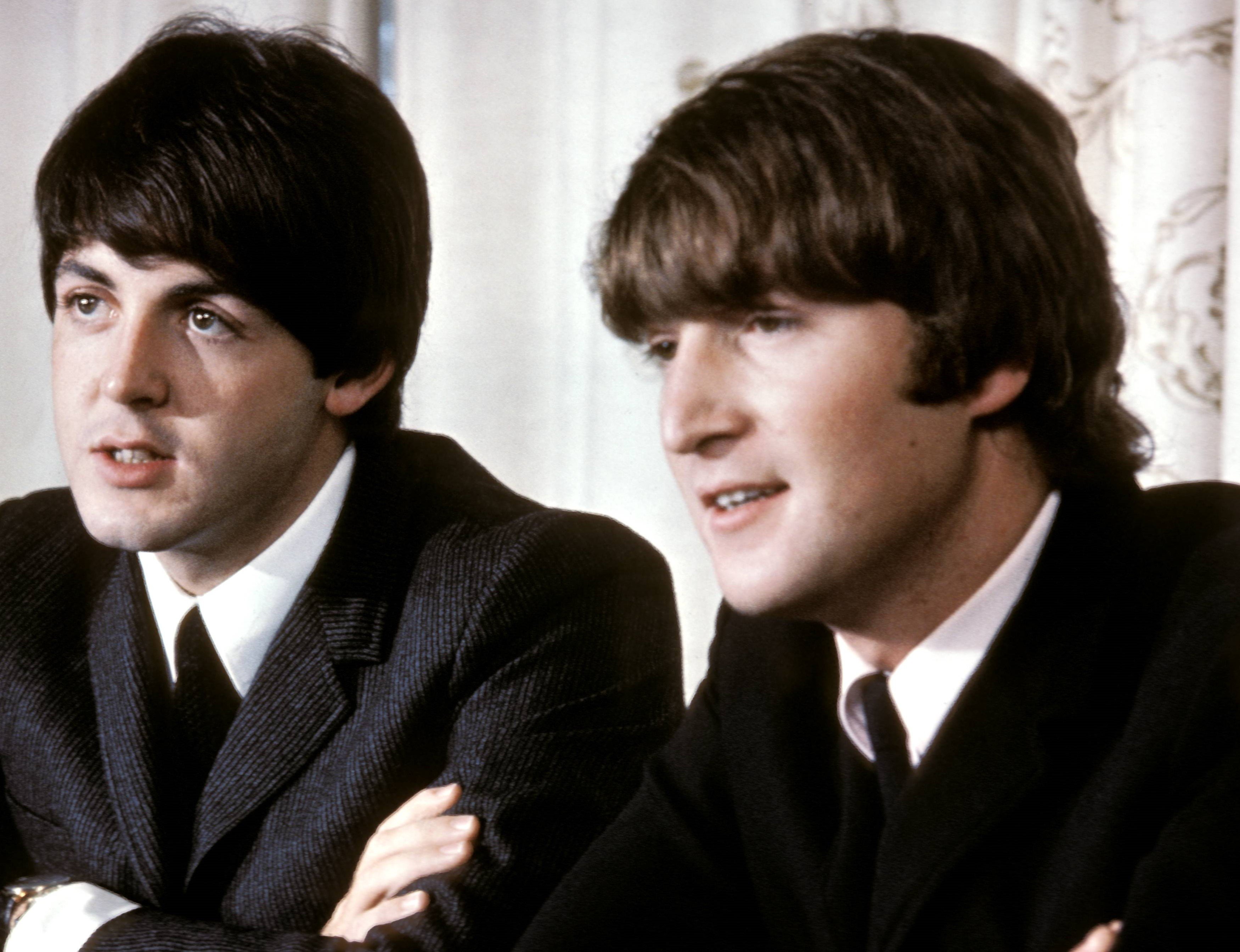 The Beatles' Paul McCartney and John Lennon wearing suits