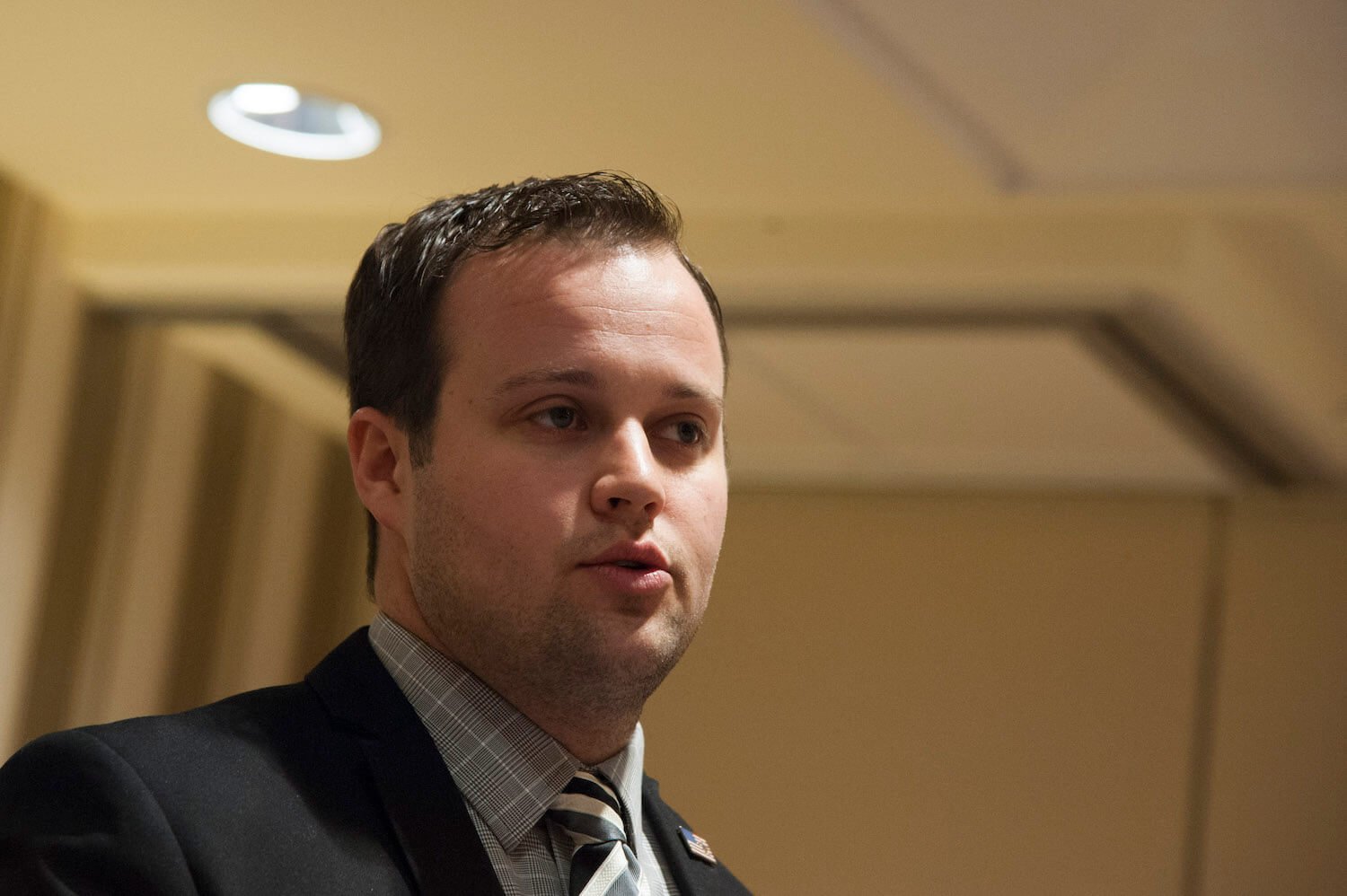 Josh Duggar of the Duggar family against a yellow background