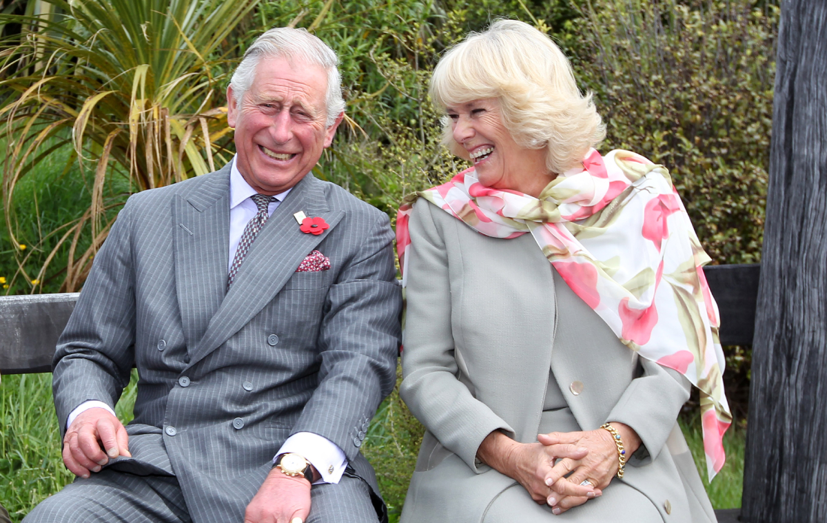 King Charles III, then Prince of Wales and Queen Consort Camilla Parker Bowles, then Duchess of Cornwall continue to laugh after a bubble bee took a liking to Prince Charles during their visit to the Orokonui Ecosanctuary on November 5, 2015