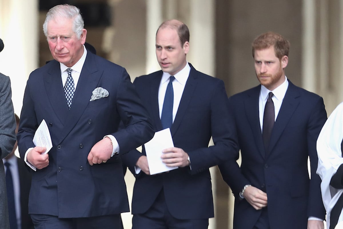 King Charles III and Prince William, who a royal commentator says are likely 'working in tandem' on Prince Harry coronation attendance, walk with Prince Harry