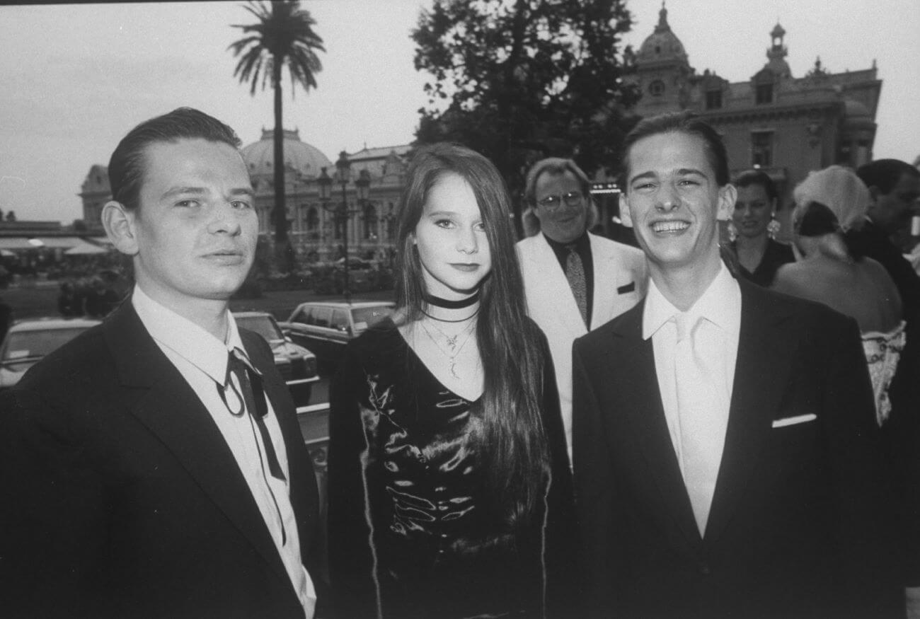 A black and white picture of Zak Starkey, Lee Starkey, and Jason Starkey standing together in a group.