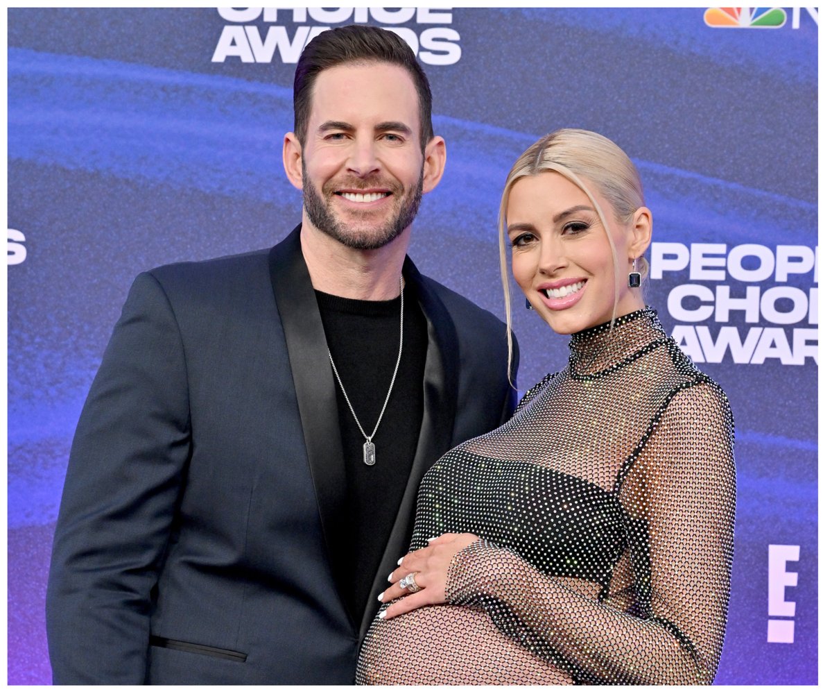 Tarek El Moussa and pregnant Heather Rae Young smile and pose together at an event.