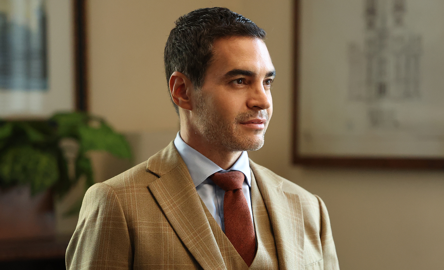 Ramón Rodriguez as Will Trent wearing a tan suit and smiling in Will Trent