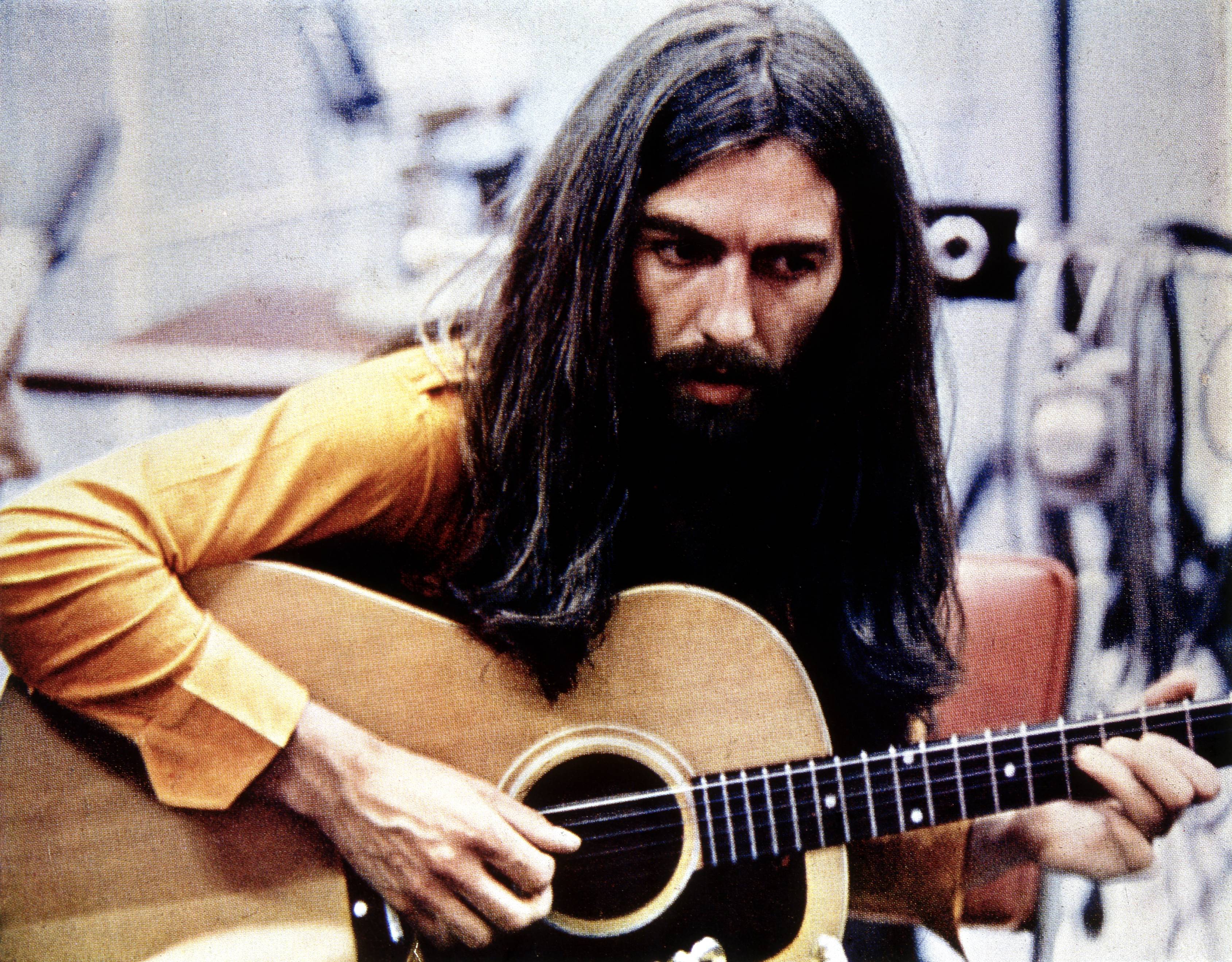 George Harrison, writer of The Beatles' "Within You Without You," with a guitar