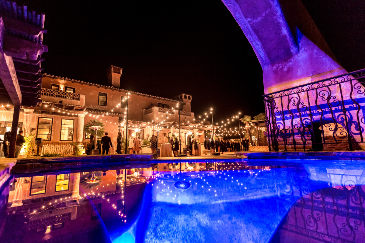 The pool at Bachelor Mansion, which is available to rent on Airbnb, is lit up by lights on the property.