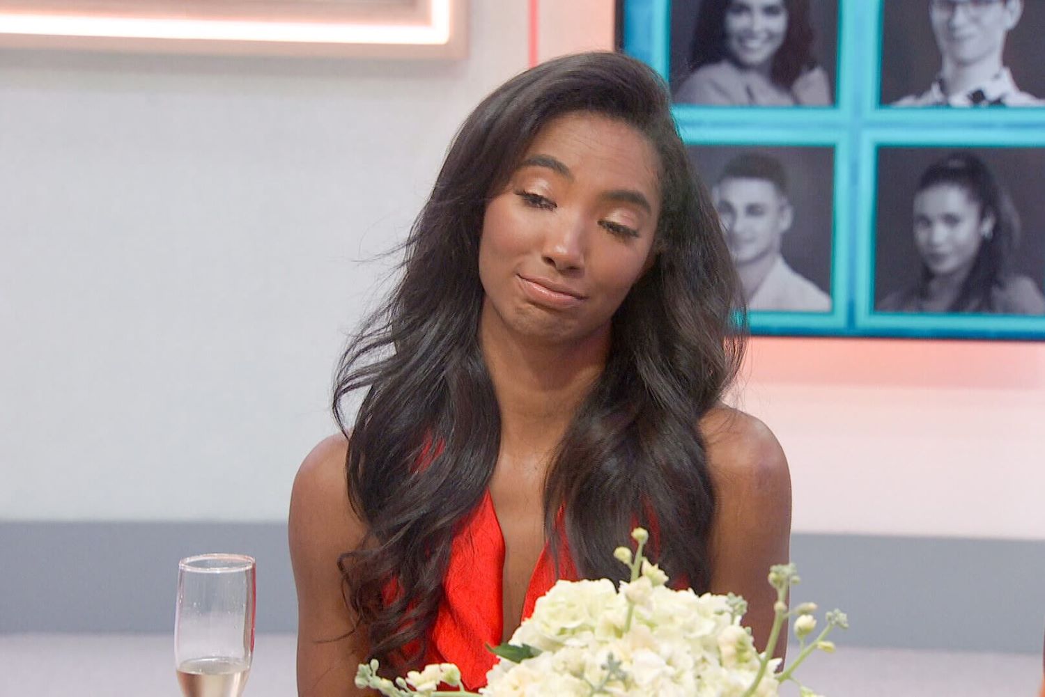 Taylor Hale, the winner of 'Big Brother 24' on CBS, wears a red dress while sitting at the 'Big Brother' house's kitchen table.