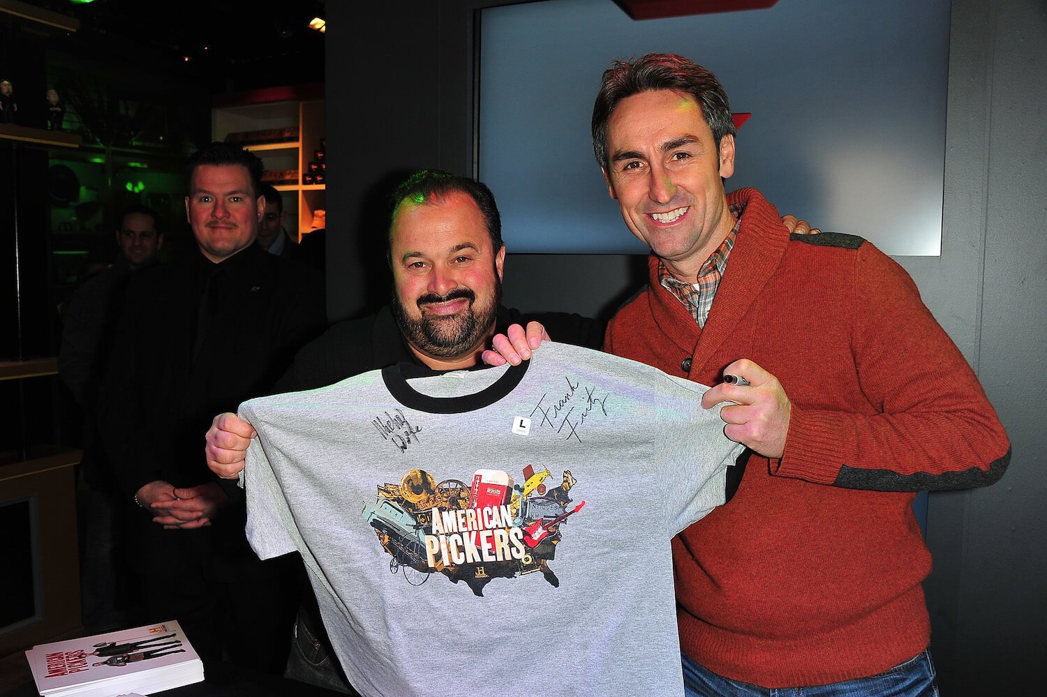 Frank Fritz and Mike Wolfe in 'American Pickers' holding up a shirt with the show's logo on it