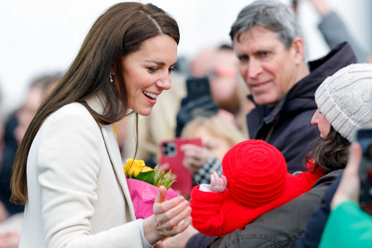 Kate Middleton, who looked 'queen-like' in Wales, smiles at a baby