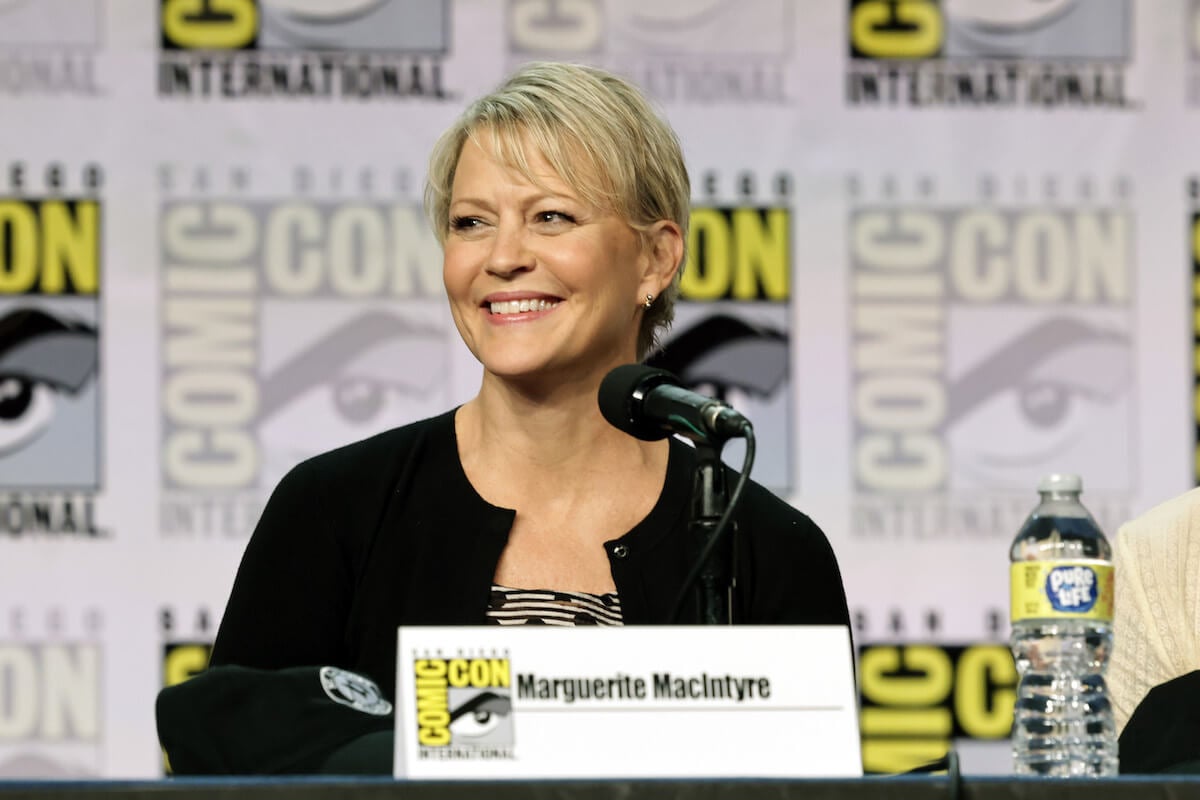 Marguerite MacIntyre sitting behind a microphone and smiling