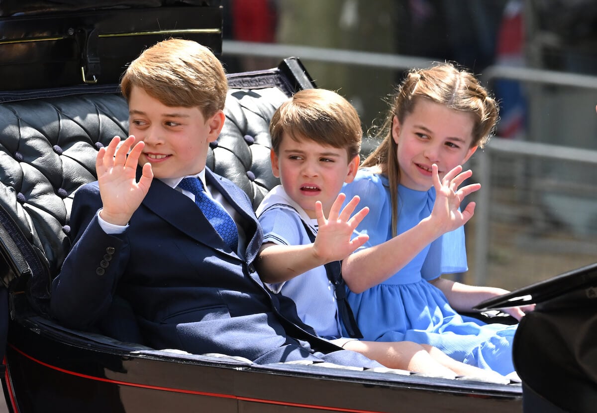 Prince George, Prince Louis, and Princess Charlotte sitting in a vehicle and waving