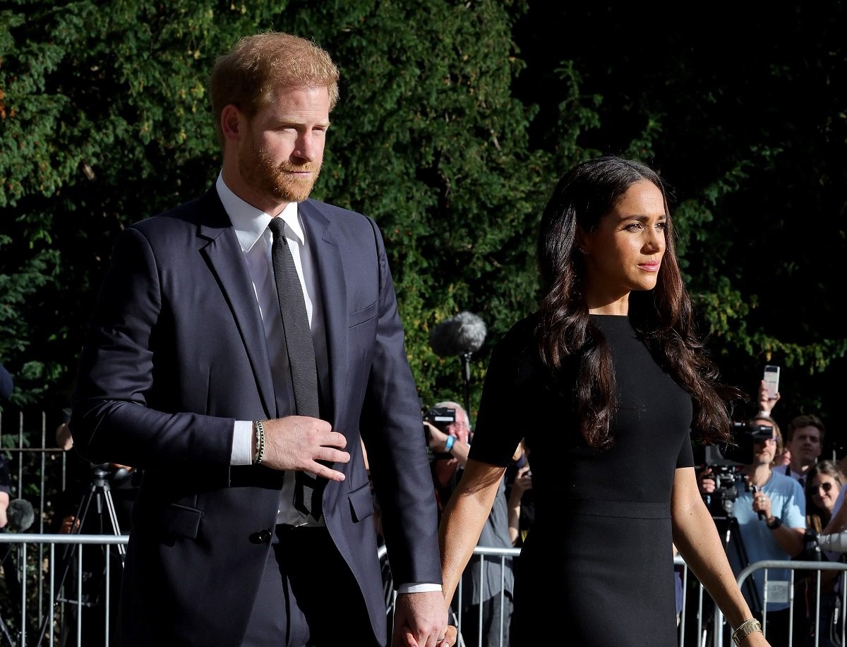 Prince Harry and Meghan Markle, who a body language expert says "silently" comforted the duke when he was visibly upset, on the long Walk at Windsor Castle to view flowers and tributes to Queen Elizabeth II