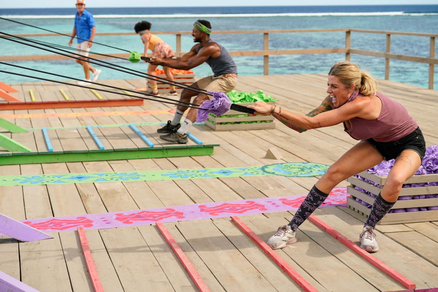 Lauren Harpe, Josh Wilder, and Carolyn Wiger compete in a Reward Challenge where they have to slingshot sand bags as host Jeff Probst looks on in 'Survivor 44' Episode 4 on CBS.