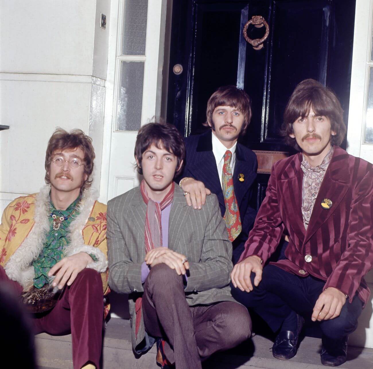 John Lennon, Paul McCartney, Ringo Starr, and George Harrison of The Beatles pose together on a doorstep. 