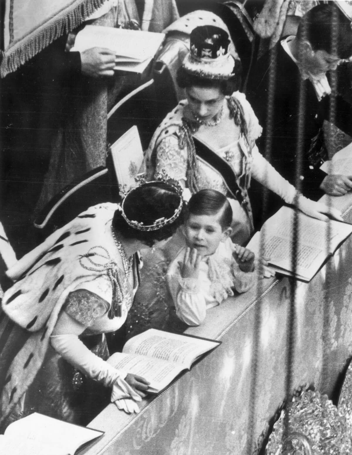 The Queen Mother talking to her grandson, then-Prince Charles, during Queen Elizabeth's coronation while Princess Margaret looks on
