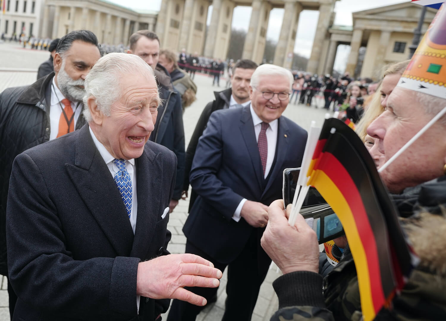 King Charles laughs while talking with a crowd of fans after one offered him a Burger King crown