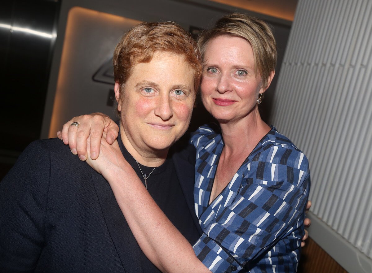 Cynthia Nixon with her arms around wife Christine Marinoni