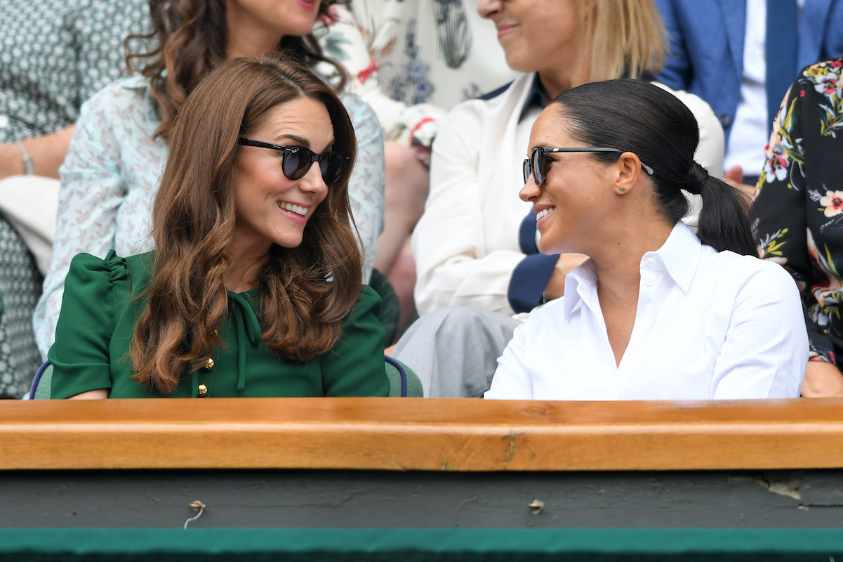 Kate Middleton and Meghan Markle don sunglasses as they chat at Wimbledon in 2018