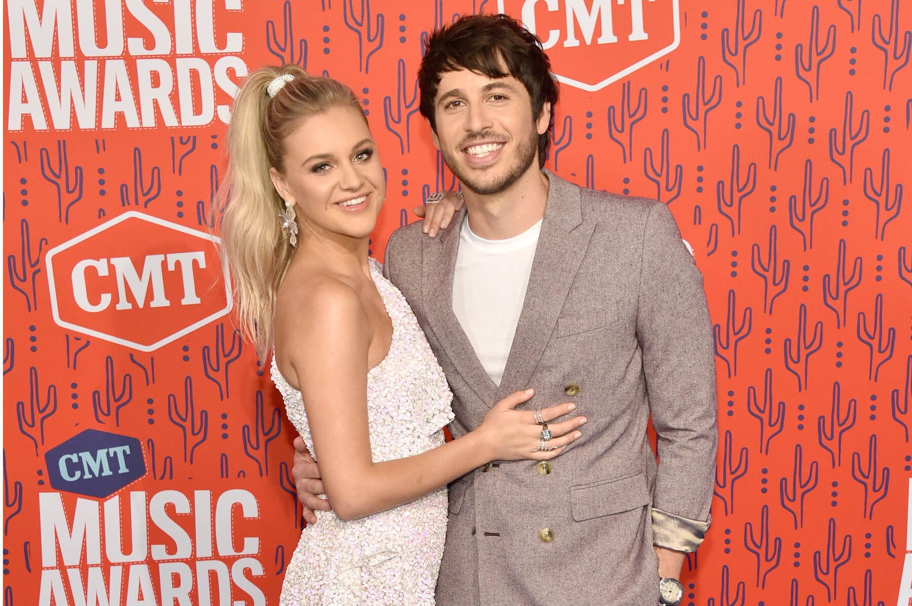 Kelsea Ballerini and Morgan Evans smiling with their arms around each other