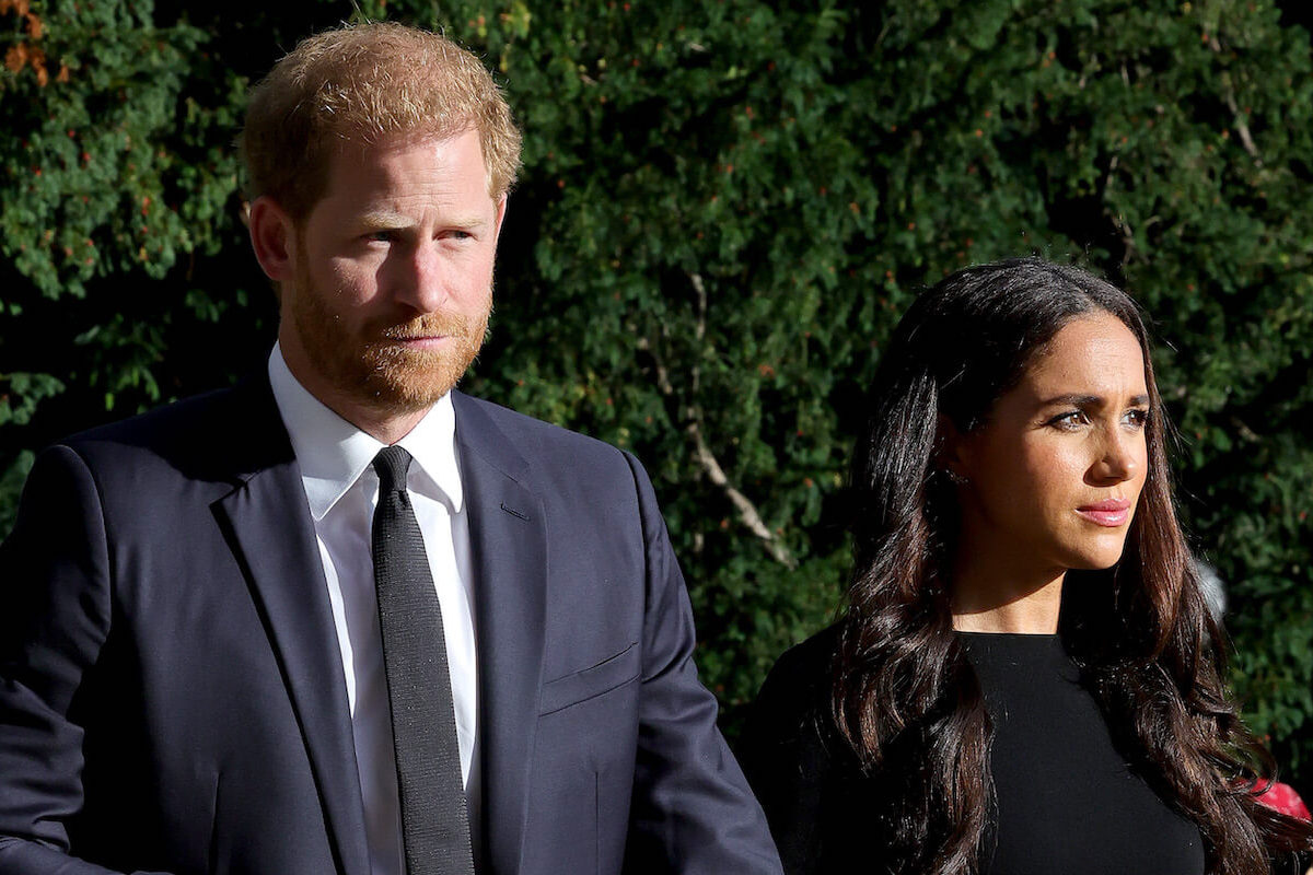 Meghan Markle, who responded to a report regarding a King Charles letter and her coronation absence, stands with Prince Harry