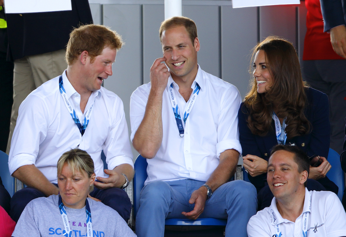 Prince Harry makes a goofy face at Kate Middleton while they watch a hockey game with Prince William in 2014
