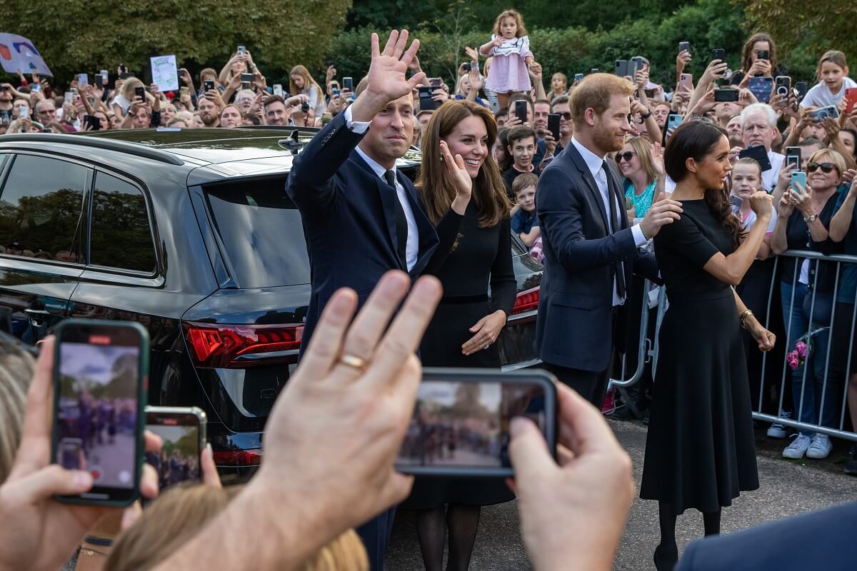 Prince William, Kate Middleton, Prince Harry, and Meghan Markle waving to well-wishers on the Long Walk outside Windsor Castle