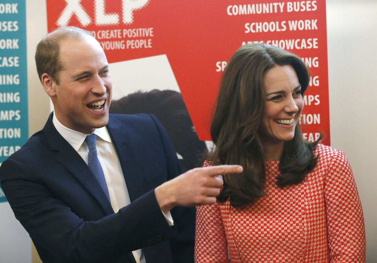 Prince William and Kate Middleton laughing, pointing finger