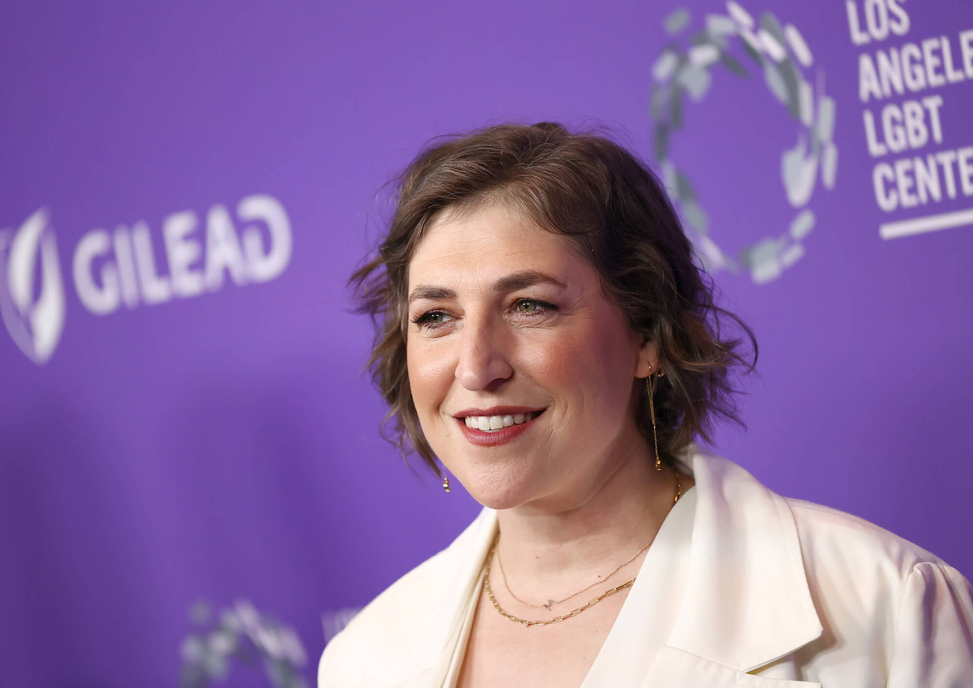 Mayim Bialik from 'Jeopardy!' against a purple background