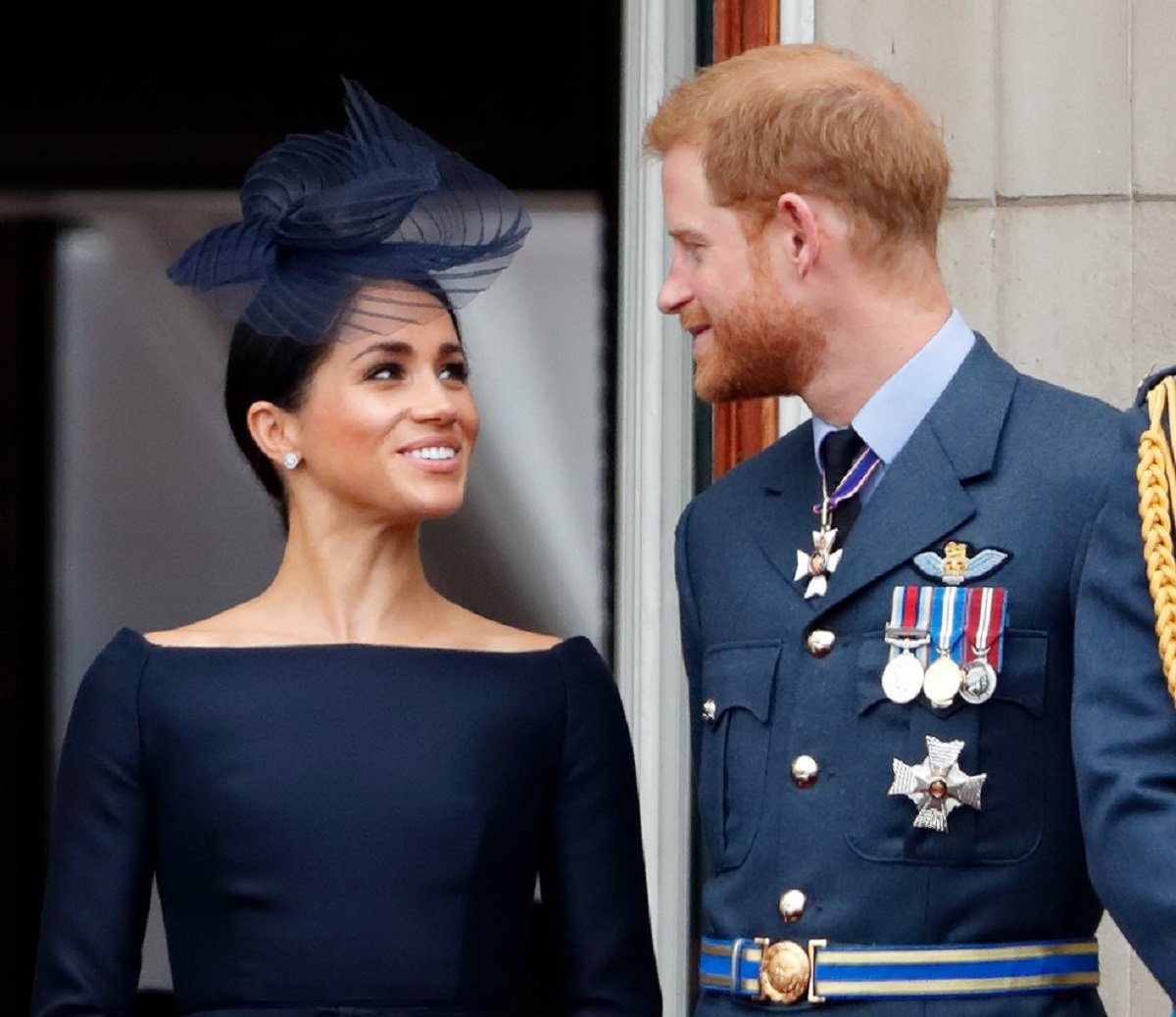 Meghan Markle and Prince Harry standing on the balcony of Buckingham Palace for a flypast