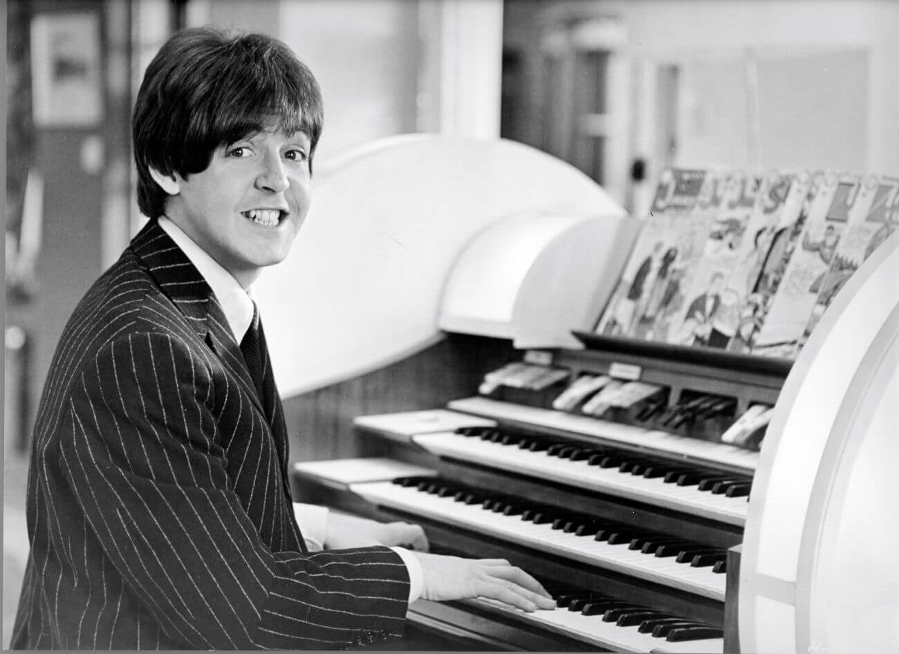 Beatles musician Paul McCartney sits at an organ and plays music.