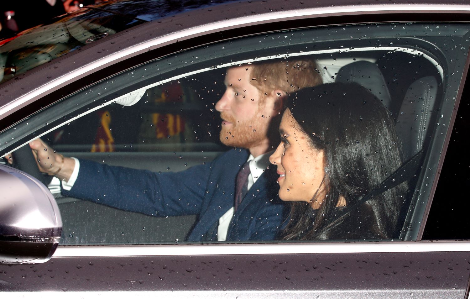 Prince Harry and Meghan Markle driving in a car.