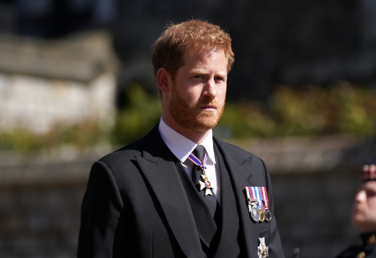 Prince Harry, who coronation organizers are hoping doesn't pull a stunt by not showing up, standing outside of St. George's Chapel at Windsor Castle for Prince Philip's funeral