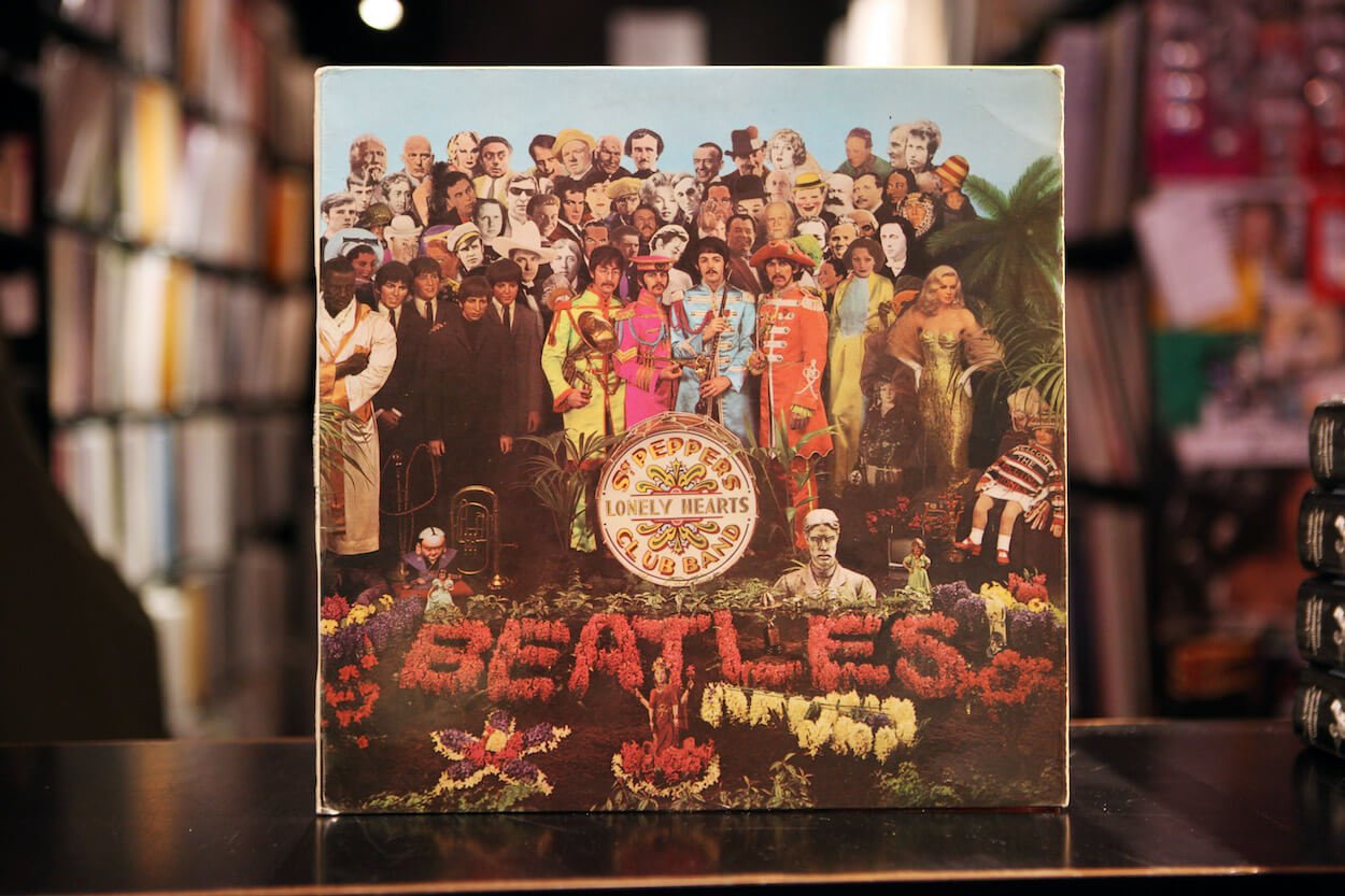 The cover of The Beatles album 'Sgt. Pepper's Lonely Hearts Club Band' includes John Lennon, Ringo Starr, Paul McCarney, and George Harrison in the center.