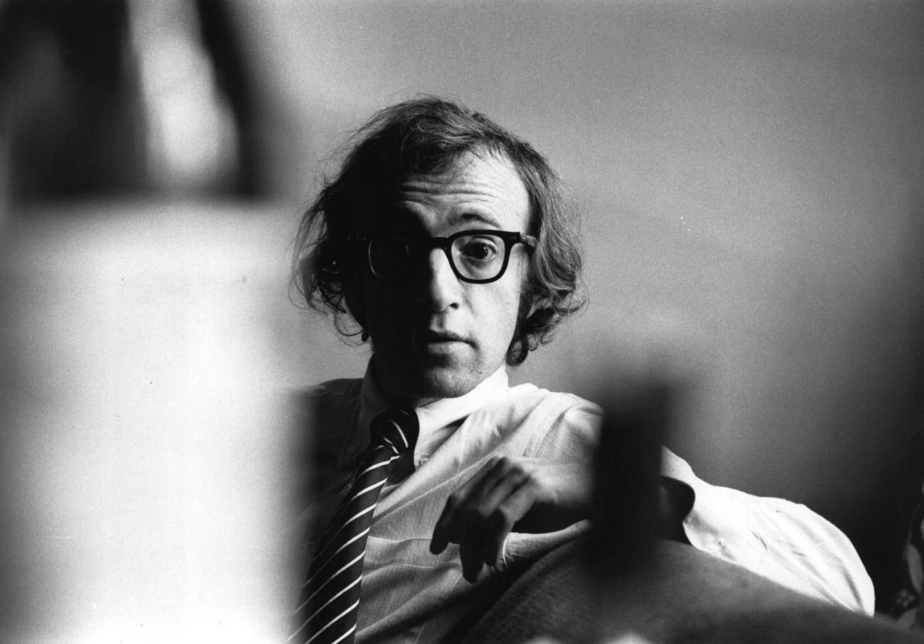 A black and white picture of Woody Allen wearing glasses and a tie.