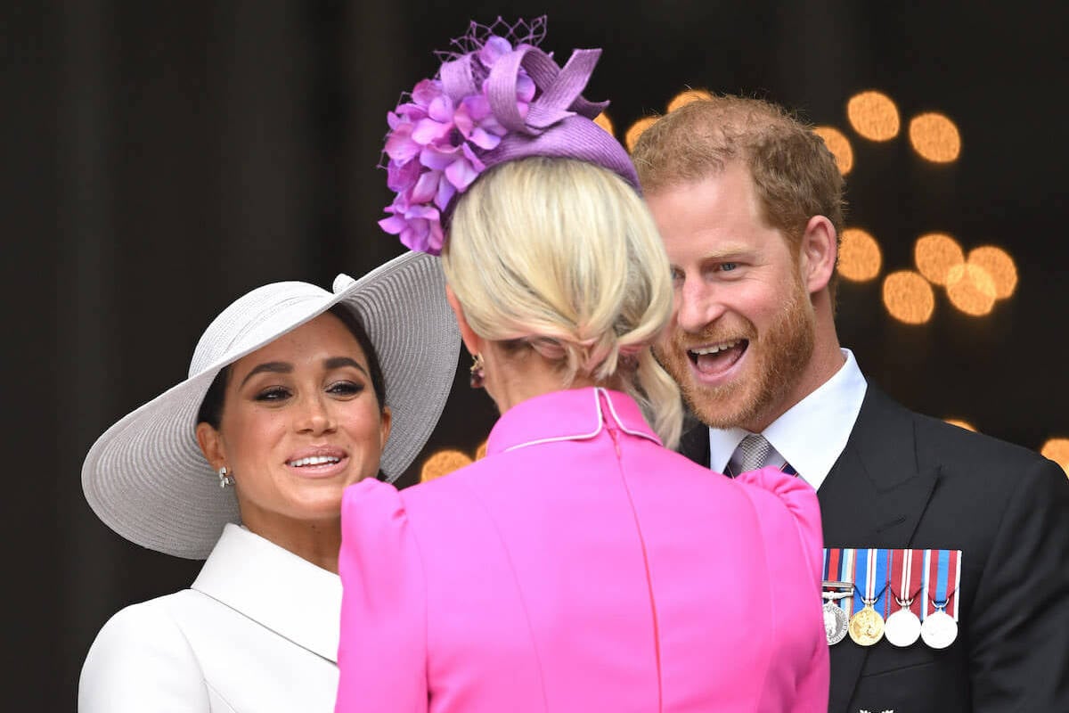 Zara Tindall, who appeared to be 'reigning herself in' at a 2022 Service of Thanksgiving, stands with Prince Harry and Meghan Markle