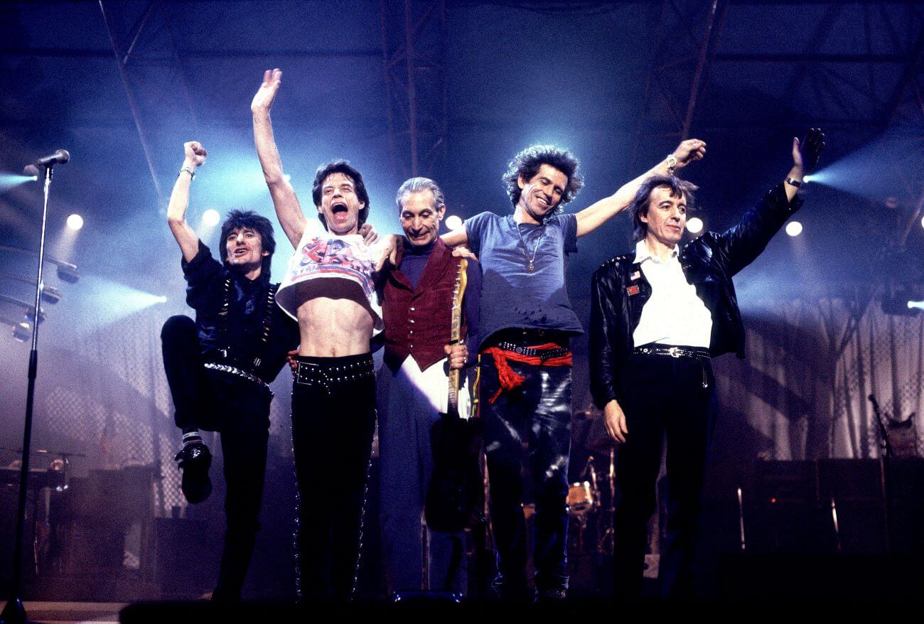 Ronnie Wood, Mick Jagger, Charlie Watts, Keith Richards, and Bill Wyman wave to the crowd while onstage.